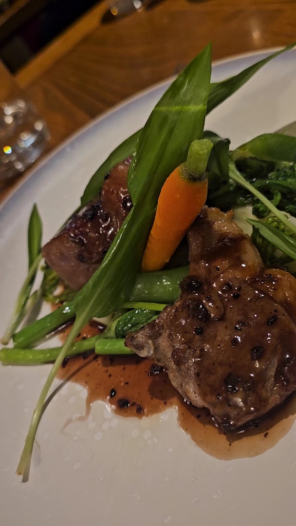 Une viande accompagnée de jeunes carottes et de feuilles